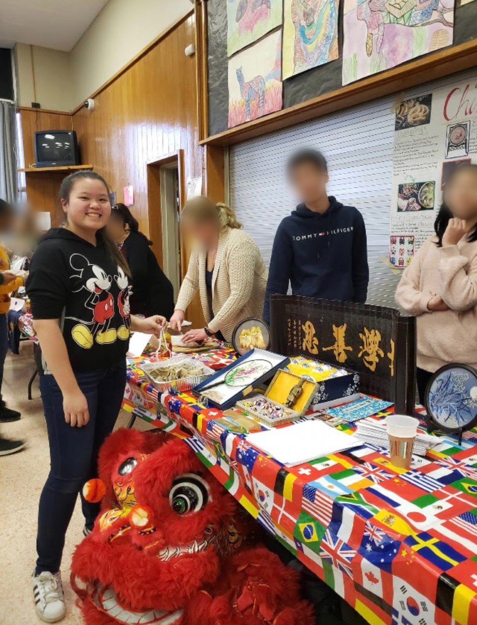 Angela standing at her Chinese Association table at a school event